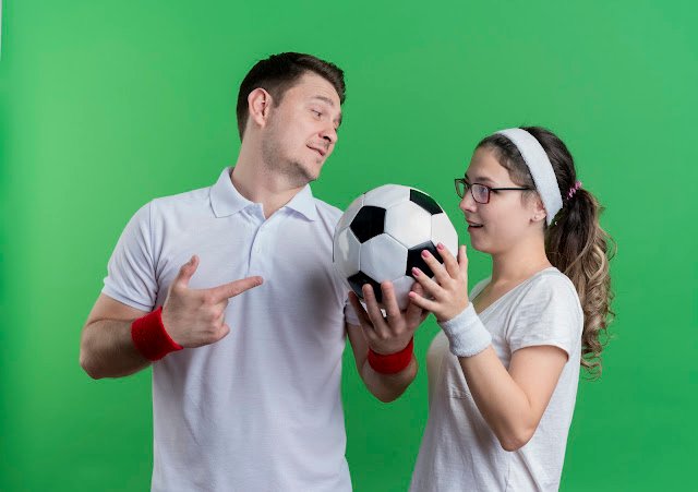 young-sporty-couple-man-woman-standing-each-other-holding-soccer-ball-green-wall-1
