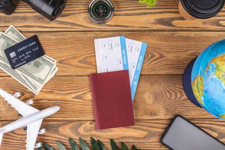166590704-documents-plane-tickets-and-other-travel-supplies-on-a-wooden-background-top-view