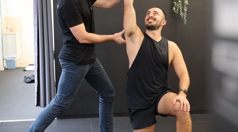 Athletestretchingwithphysiotherapistguidanceinamodernclinicsetting