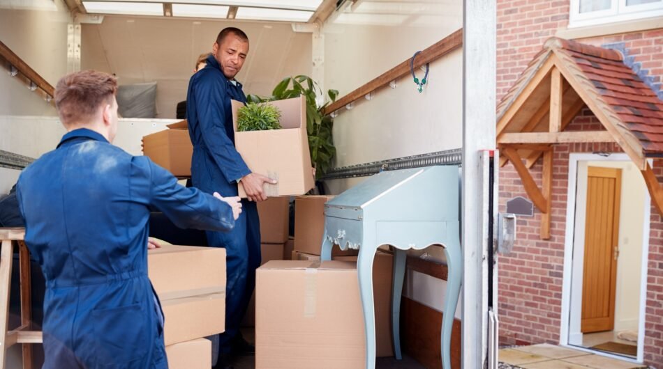 removal-company-workers-unloading-furniture-and-boxes-from-truck-into-new-home-on-moving-day