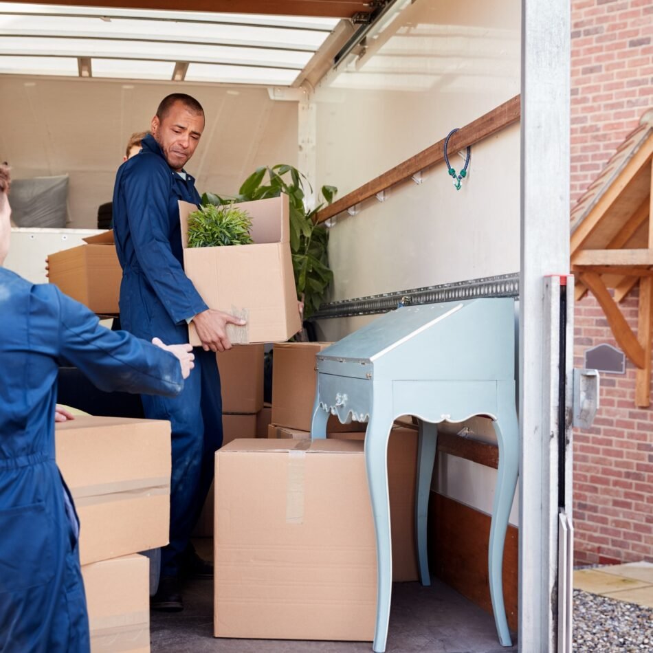 removal-company-workers-unloading-furniture-and-boxes-from-truck-into-new-home-on-moving-day
