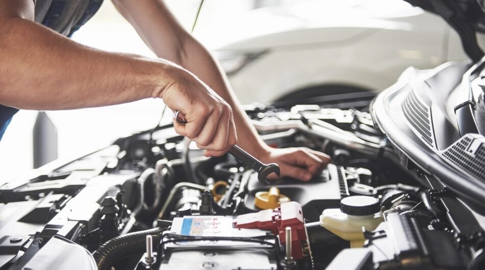 muscular-car-service-worker-repairing-vehicle-1